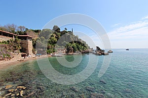 The shore of the Mediterranean Sea. On the mountain is a hotel. Antalya, Turkey, April 6, 2019