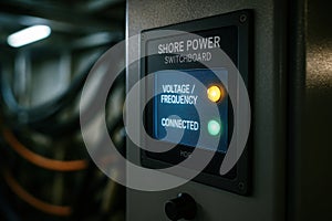 Shore power system display panel showing voltage, frequency and connection status with active LED indicators