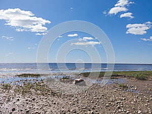 Shore of the sea. seascape with horizon line. sky with clouds. silt coast