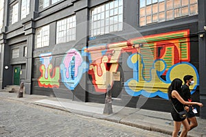 Shoreditch district in East London during Covid 19 lockdown with people wearing masks on the streets