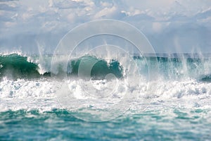 Shoreline breaking waves in turquoise colored ocean