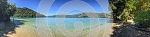 A shoreline level sweeping panoramic view of the beautiful Marlbough Sounds, New Zealand, sparkling waters, clear blue skies