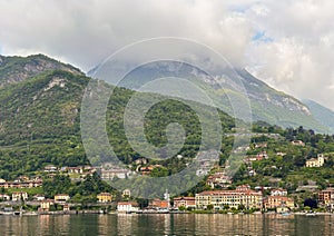 Shoreline of Menaggio on Lake Como with cloud shrouded hilltops in the background.