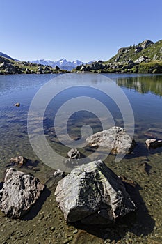 Shoreline of the mountain lake in Pas de la Coche vertical photo