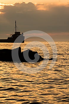 Shoreline Rocks And A Great Lakes Freighter At Sunrise