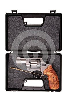 Short-barreled revolver with a wooden handle in a special plastic case for transportation and storage isolated on white background