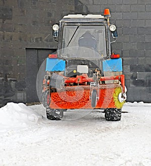 Short break in work on snow cleaning. Snowplow near wall