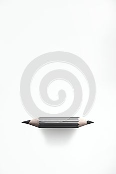 Short gray pencil sharpened at both ends, on white background. Vertical image with copy space. photo