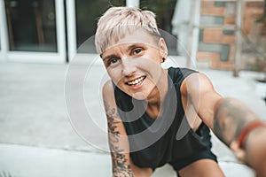 Short haicut woman making selfie sitting at her house outdoors