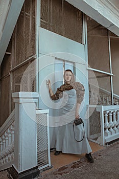 Short-haired girl in strange clothes and makeup posing in an old building