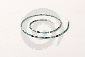 A short necklace or beads made of natural turquoise and 925 sterling silver. Handmade jewelry. Necklace beads handmade on a light
