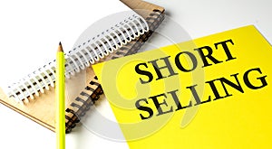 SHORT SELLING text written on a yellow paper with notebook