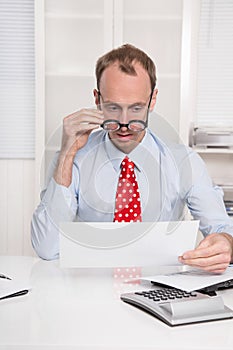 Short sighted at work - balding businessman looking through glasses at document - funny photo