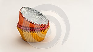 Short stack of Colorful cupcake wrappers stacked upside right on a white background