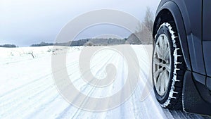 A short stop during a winter road trip. The car is parked on the side of a snow-covered country road. On one side of the road is a