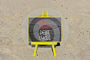 Short-term debt cycle symbol. Concept words Short-term debt cycle on beautiful black chalk blackboard. Beautiful sand beach