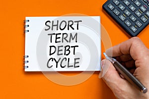 Short term debt cycle symbol. Concept words Short term debt cycle on beautiful white note. Beautiful orange background.