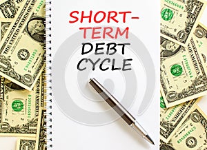 Short-term debt cycle symbol. Concept words Short-term debt cycle on beautiful white note. Black pen. Beautiful dollar bills