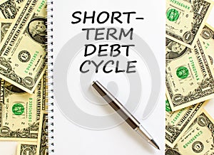 Short-term debt cycle symbol. Concept words Short-term debt cycle on beautiful white note. Black pen. Beautiful dollar bills