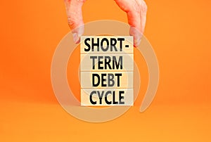 Short-term debt cycle symbol. Concept words Short-term debt cycle on beautiful wooden block. Beautiful orange table background.