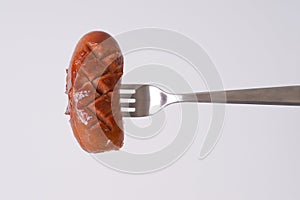 Short thick sausage on fork photo