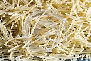 Short thin vermicelli on the whole background. texture of dry yellow pasta