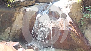 A Short Waterfall Flows Through A Large Natural Rock Wall