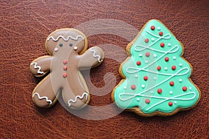 Shortbread Cookies In Shape Of Funny Man And Pine Tree On Brown Leather Surface