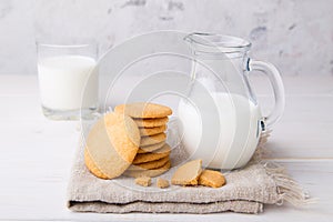 Shortbread kamut cookies with jug and glass of milk on napkin