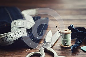 Shortening jeans. Measuring tape, scissors, spools of thread and chalk. Jeans cutting photo