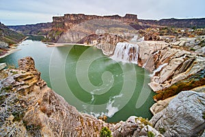 Shoshone Falls in Idaho going down large river surrounded by cliffs in early spring