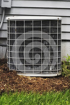 A shot of an air cooling unit outside of a suburban home