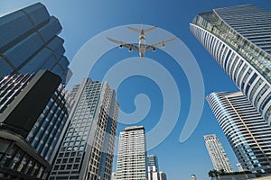 Shot of airplane flying above skyscrapers in City of Bangkok dow