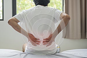 Shot of Asian man suffering backache when he waking up in the morning