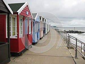 Shot of assorted colorful cabins on a pathway by the sea under a cloudy sky