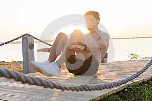 A shot of an athlete doing sit-ups outside.