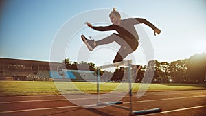Shot of Athletic Fit Man in Grey Shirt and Shorts Hurdling and Jumping Over Barriers on a Warm Sum