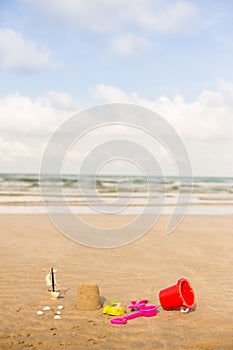 Shot of the beach with a spade and bucket in foreground.