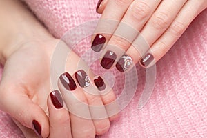 Shot beautiful manicure with flowers on female fingers. Nails design. Close-up