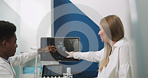 Shot of a beautiful young pregnant woman sitting on the couch in ultrasound examination room and having consultation