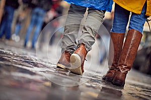 Shot from below of a young couple in love who is walking the city on a rainy day. Walk, rain, city, relationship