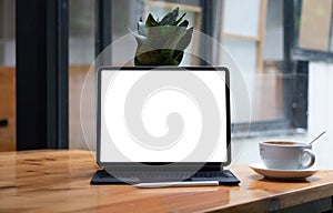 Shot of blank screen tablet with keyboard on wooden desk in office