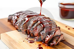 shot of brush smothering ribs with homemade bbq sauce