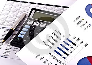 Financial tools, calculator, pen and specs over a report