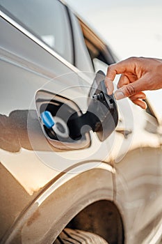 Shot of businessman opening fuel tank of his car