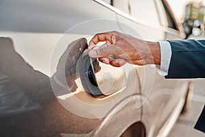 Shot of businessman opening fuel tank of his car