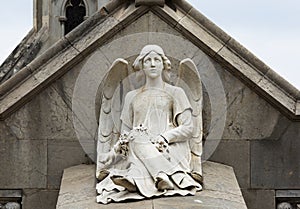 Angel with flowers sitting on the grave