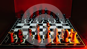 Shot of the confrontation between white and black chess pieces standing on a chessboard