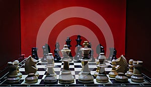 Shot of the confrontation between white and black chess pieces standing on a chessboard