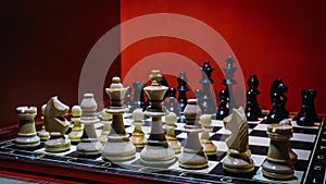 Shot of the confrontation between white and black chess pieces standing on a chessboard